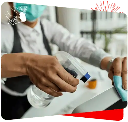 Disinfecting keyboard with spray to ensure a clean, sanitized workspace.